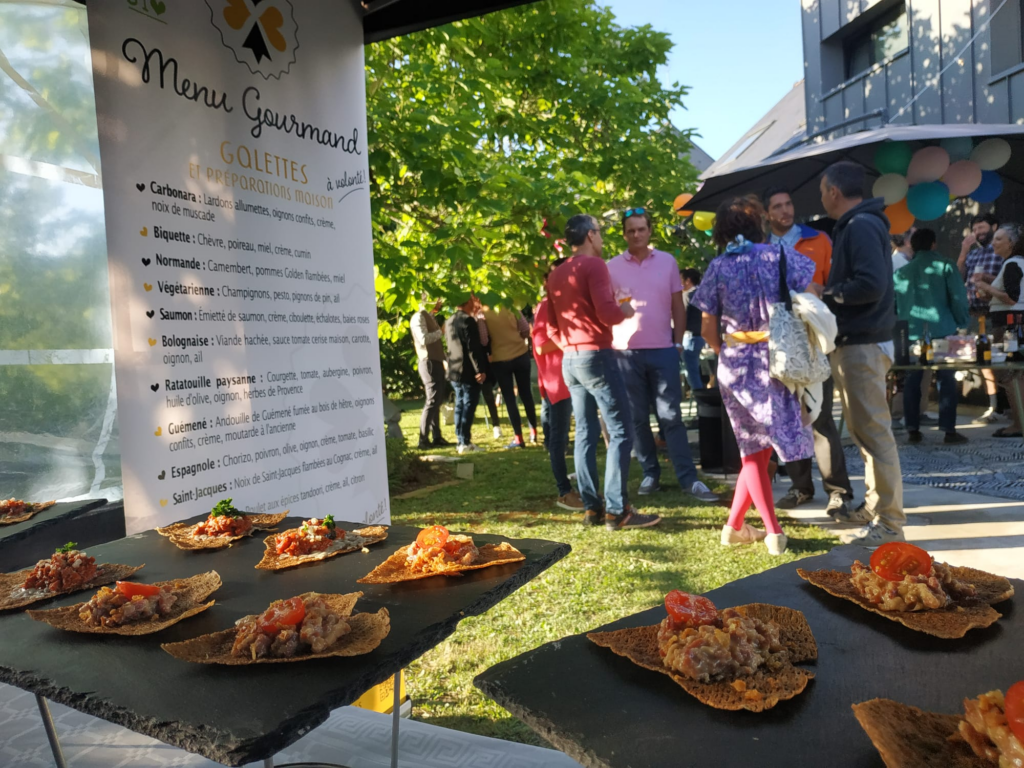 Buffet de pot de départ en retraite : invités autour des mini-galettes en extérieur