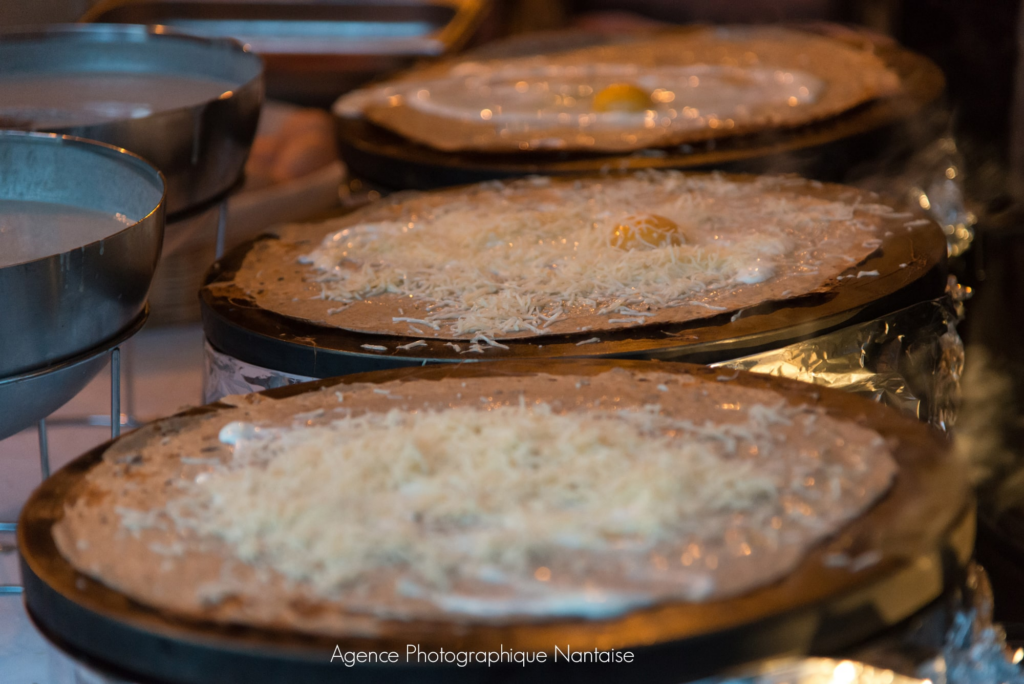 Bar à crêpes : galettes de blé noir garnies en cuisson sur les billigs